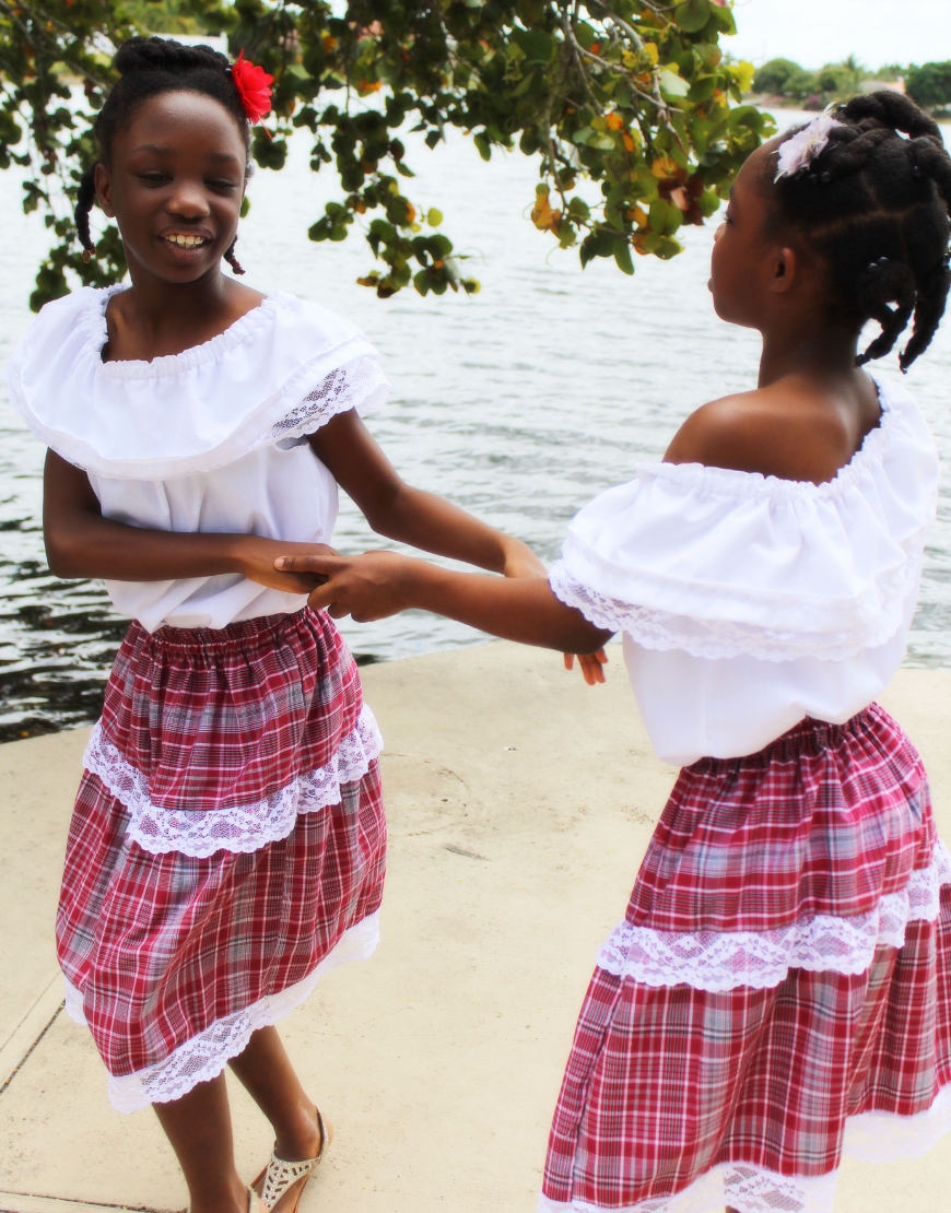 Kids in beautiful versatile Jamaican bandana outfits engage in play time